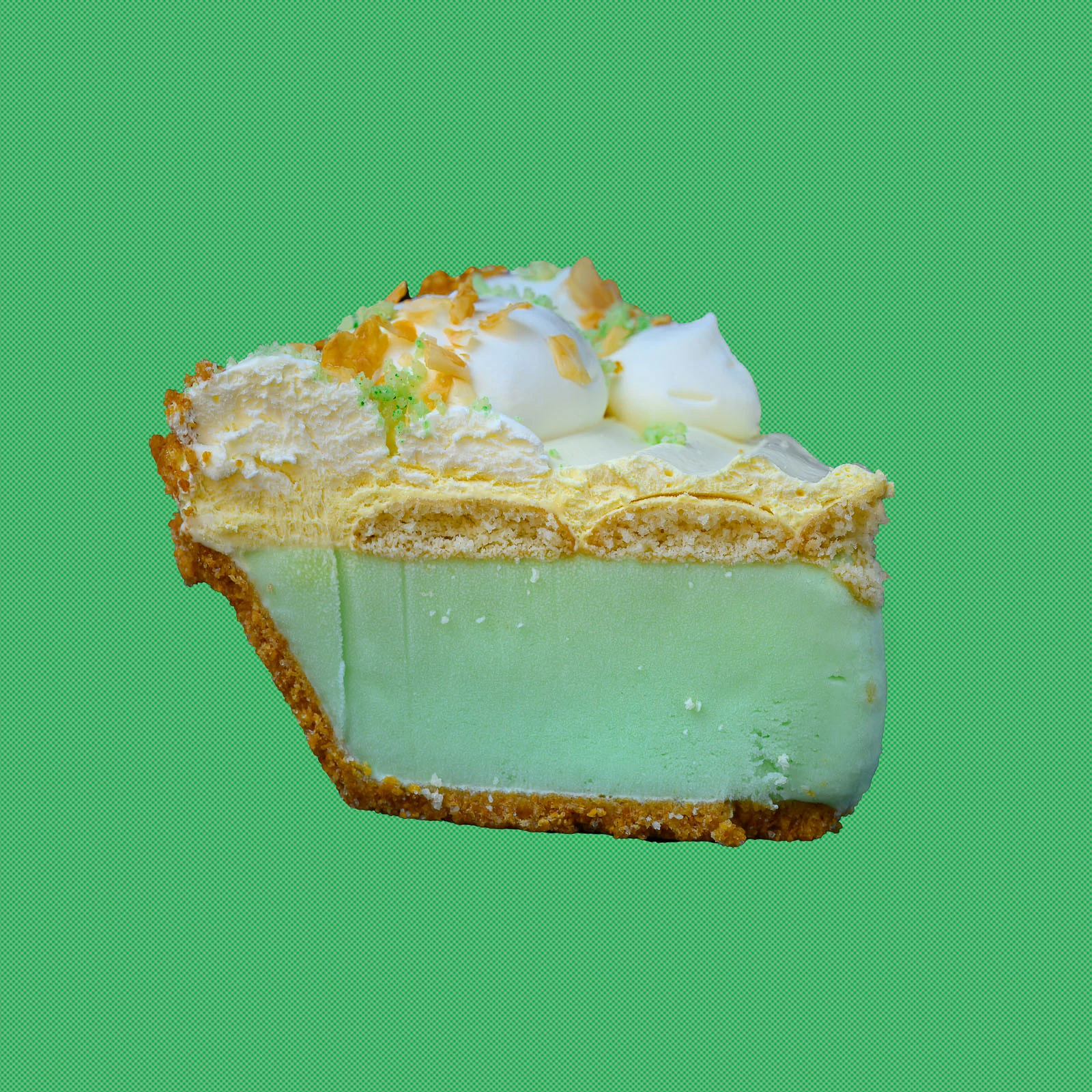 Slice of mint-green Softserve Pie with whipped topping on a green background