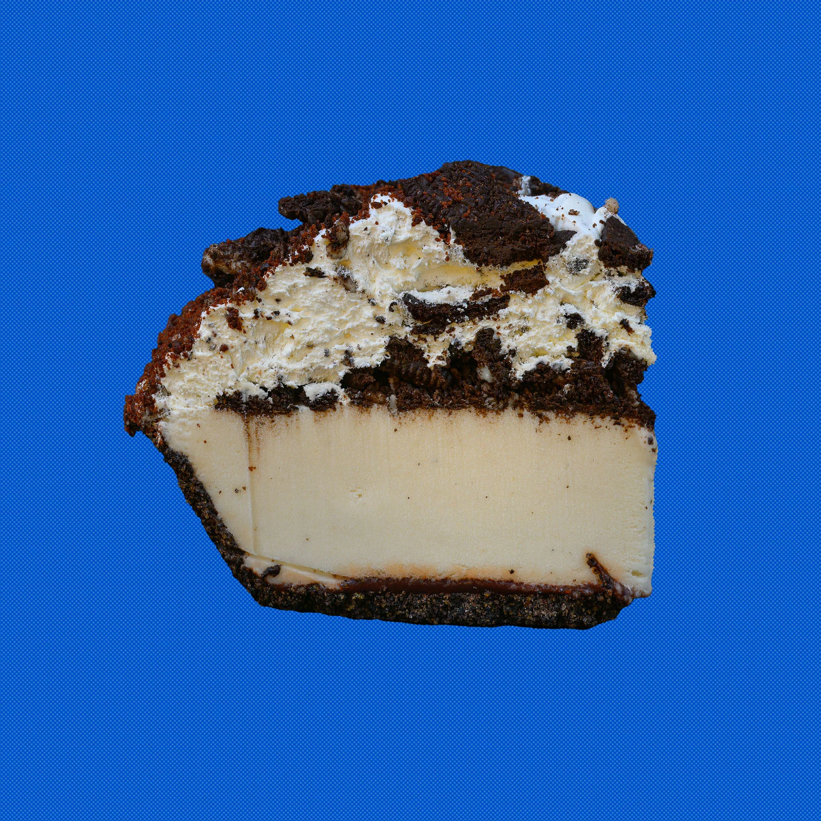Softserve Pie slice topped with chocolate cookie pieces on a blue background