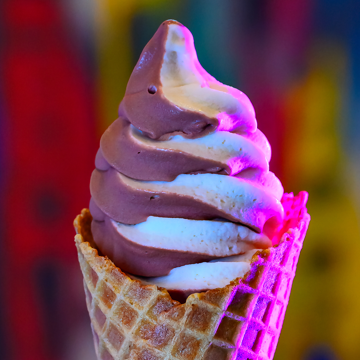Chocolate and vanilla swirled soft serve ice cream in a waffle cone